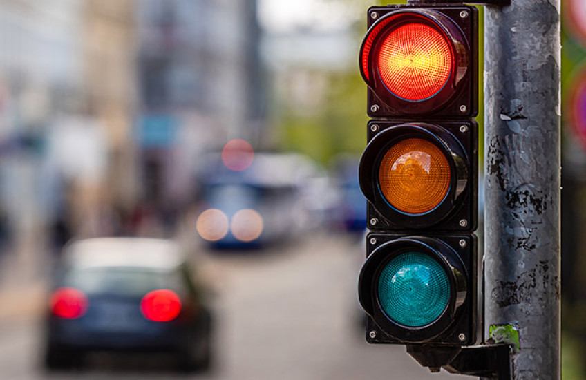 Photo of traffic signal on red, city street blurred out in background