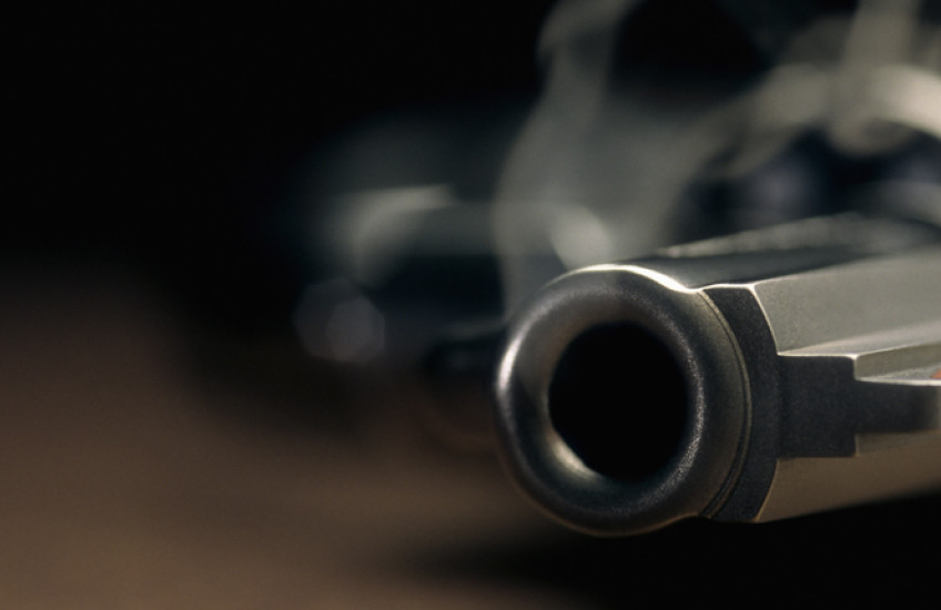 A smoking gun lies on a table.