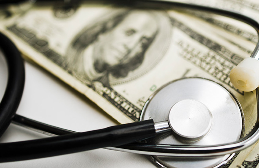 photo of stethoscope on top of money
