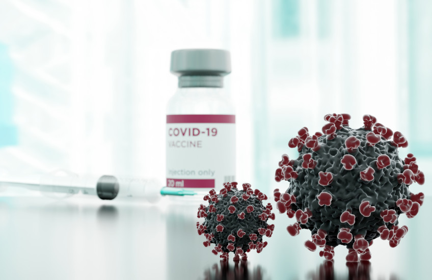 Clinical image showing syringe, vaccine vial, and stylized covid spike proteins