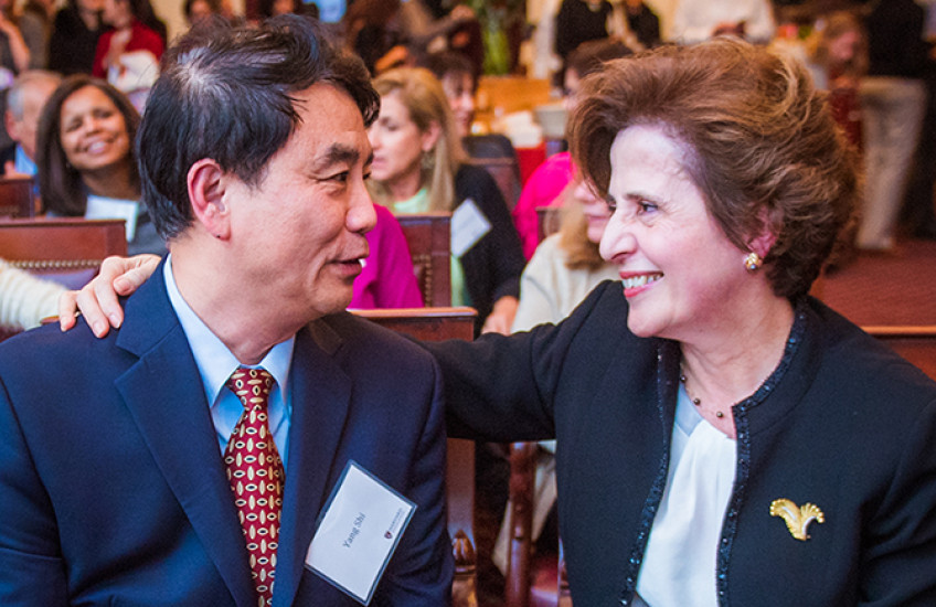 Man and woman smile at each other with hand on shoulder