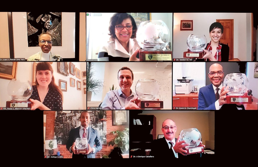 : Portraits of eight people smiling, with seven award winners holding commemorative crystal bowls. 