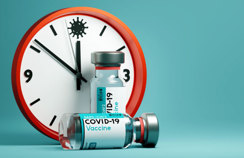 A Clock together with a COVID vaccine vial 