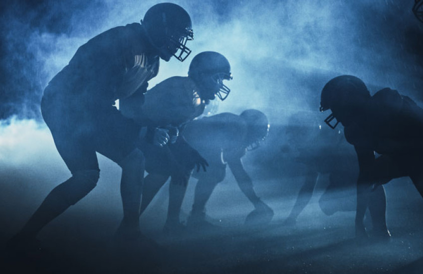 Football players in silhouette on the playing field