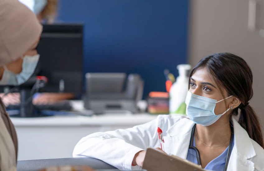 Photo of a health care provider interviewing a female patient 