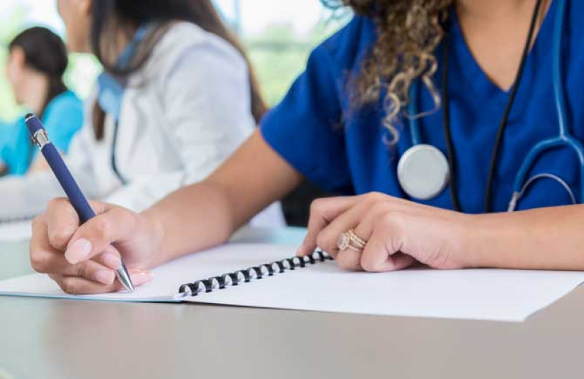 Image of nondescript med students working at a desk