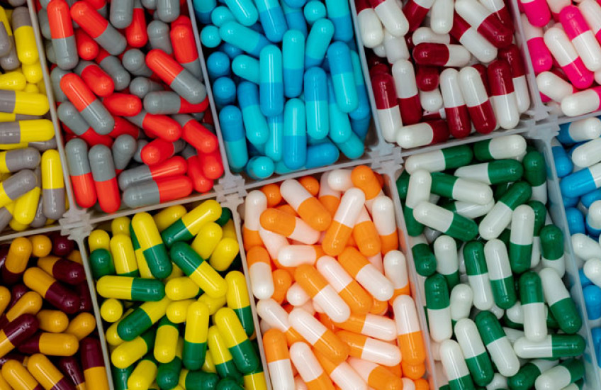Multiple rectangular compartments filled with large, multi-colored pills