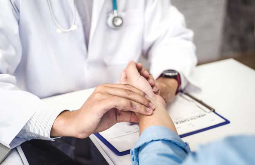 Stock image of a doctor's hands taking a patient's pulse 