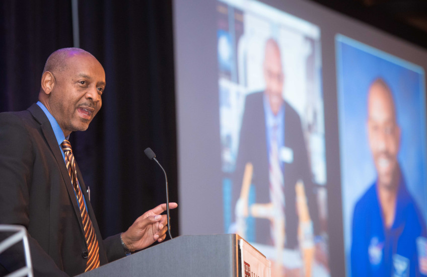 Satcher speaking at a podium at the Spotlight dinner
