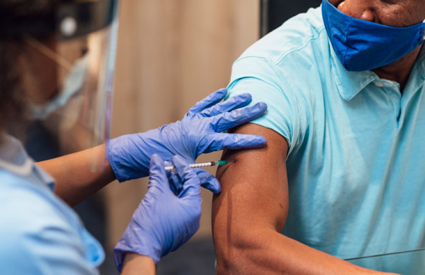 Photo of an African American man getting a vaccination 