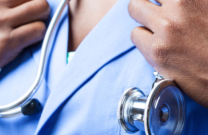 Image of a Black physician, just hands, scrubs and a stethoscope