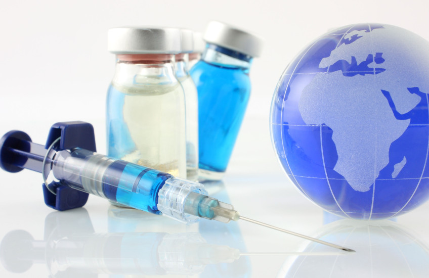 Image with syringe, vaccine bottles and a small Earth globe