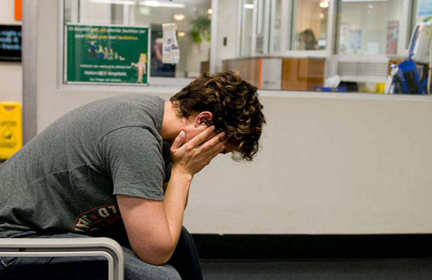 Stock image of a young man with his head in his hands 