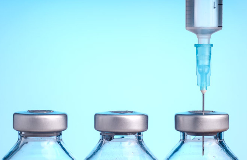 Image of 3 vaccine bottles & a syringe 
