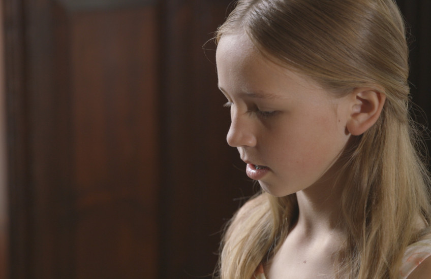 close up of a 12-year-old girl playing piano