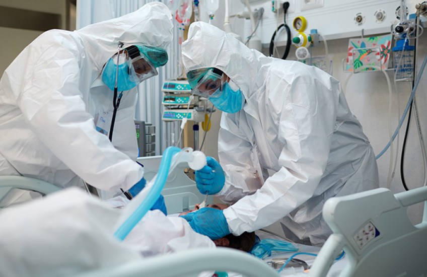 two health care workers intubating a patient with covid-19