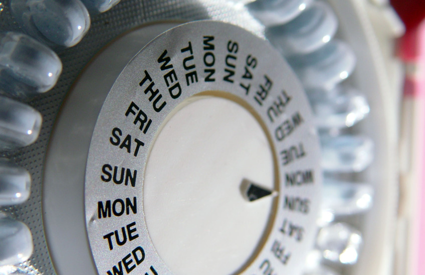 Close-up of a pill organizer listing days of the week.