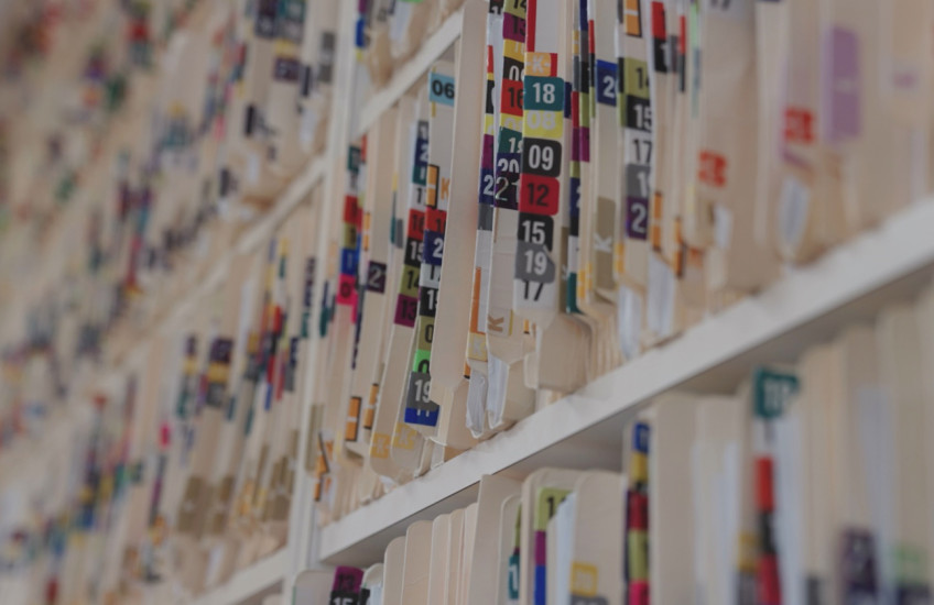 Colorful folders on a crowded shelf