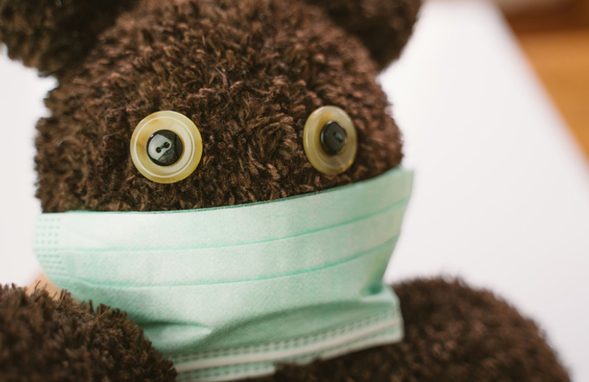 Photo of a teddy bear wearing a surgical mask