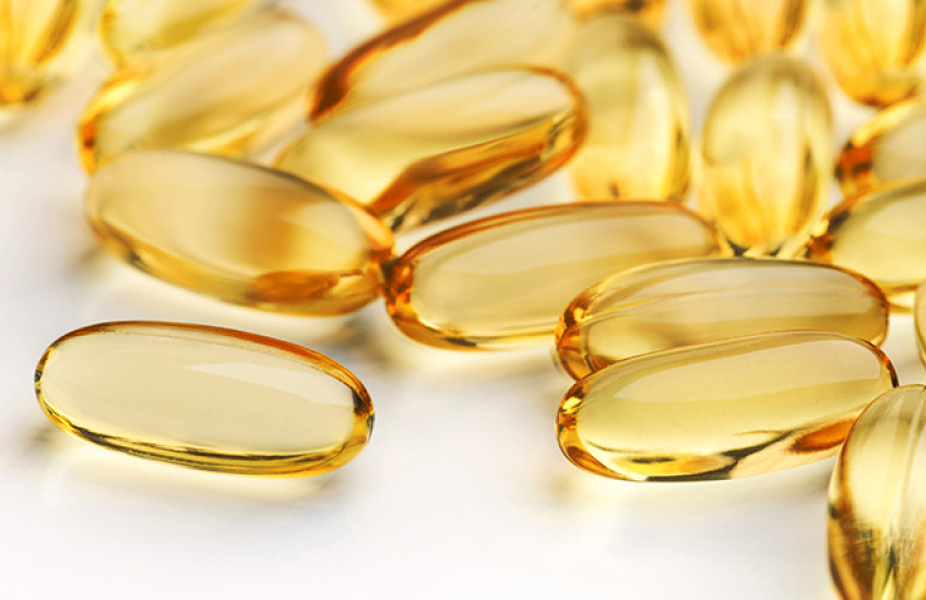 Golden liquid capsules on a plain surface