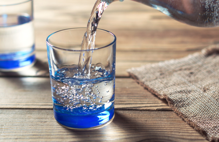 Photo of water being poured from a pitcher into a glass