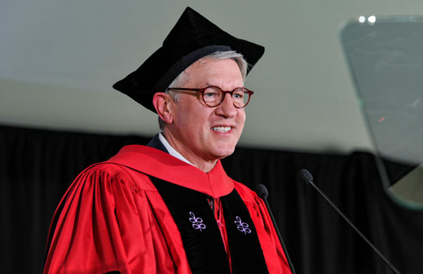 Giannobile wearing regalia speaking into microphone