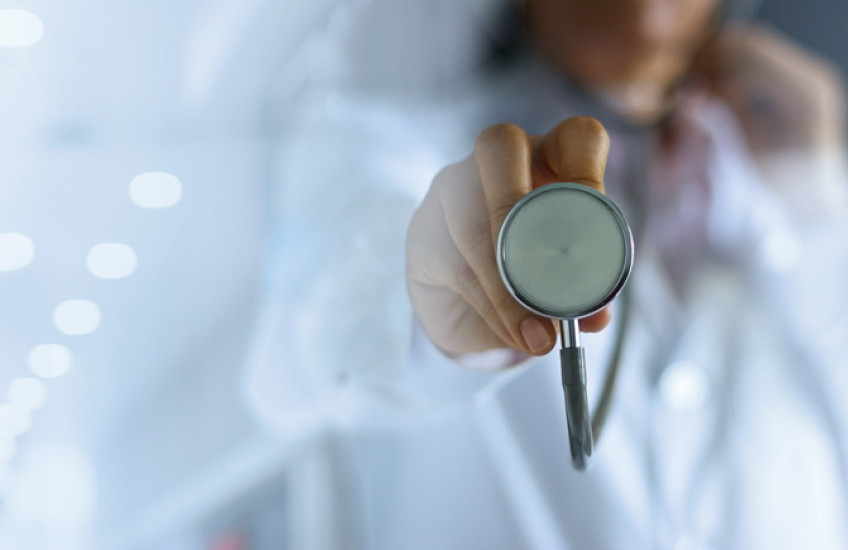 Closeup of a woman holding a stethoscope.