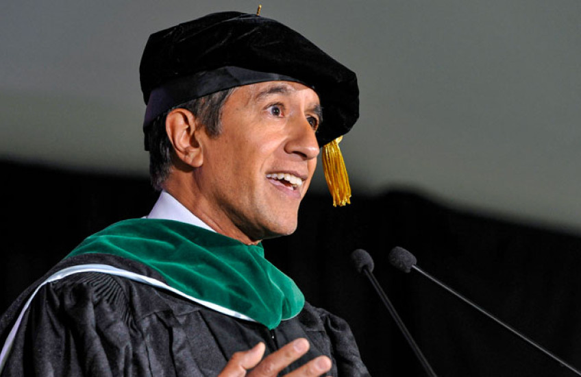 Gupta in regalia speaking into microphone