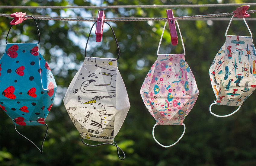 Diverse, colorful masks hang on a laundry line.
