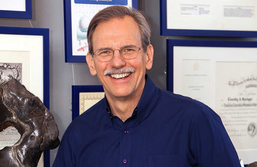 Head shot of a smiling middle-aged white man with glasses and a moustache