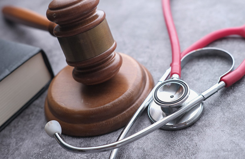 photo of stethoscope, gavel and law book