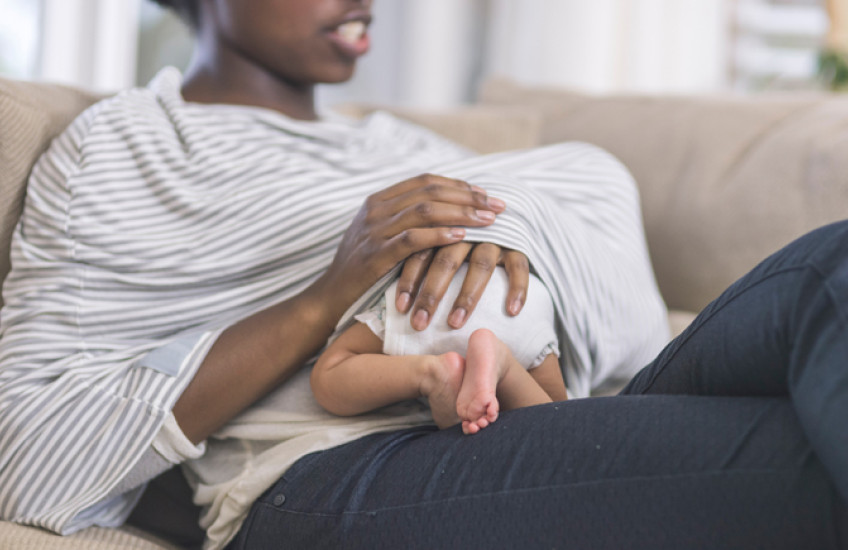 baby under woman's shirt breastfeeding