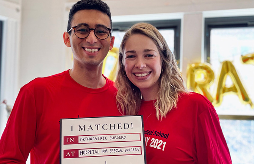 Troy Amen with his fiancee holding "I Matched" sign