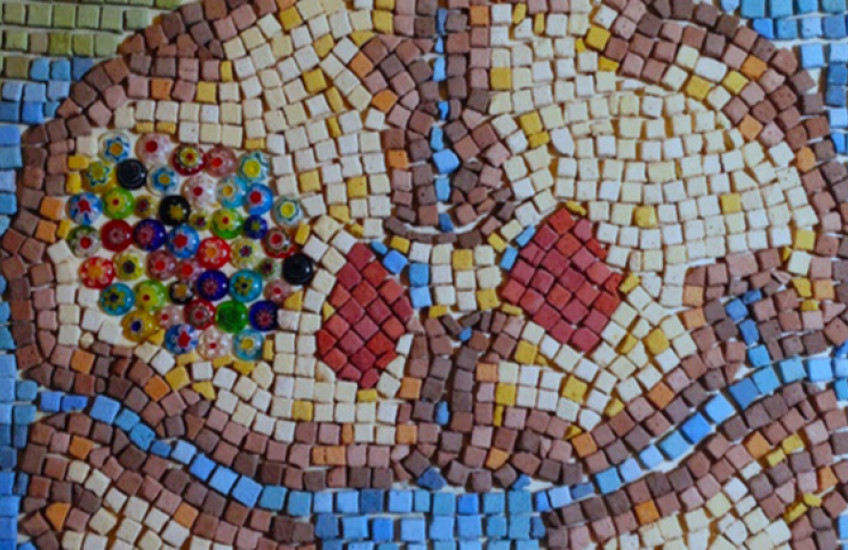 Mosaic of brain with colorful cluster of tiles in one hemisphere