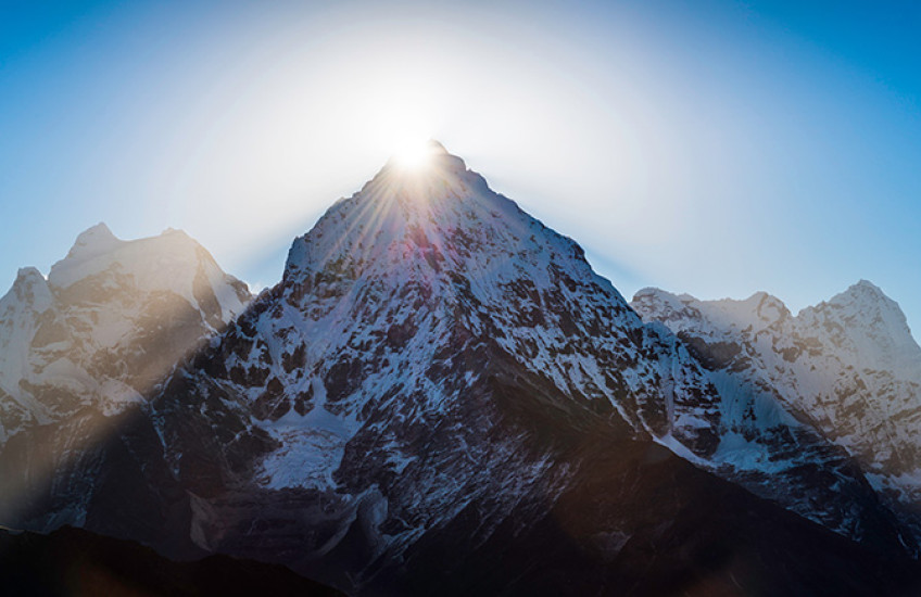 photo of mountain peak with sun shining