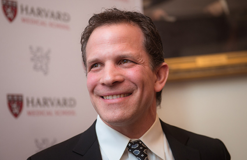 White man in suit and tie, smiling
