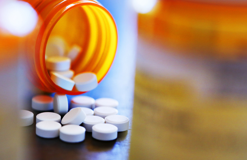 A bottle of pills spilling on a table