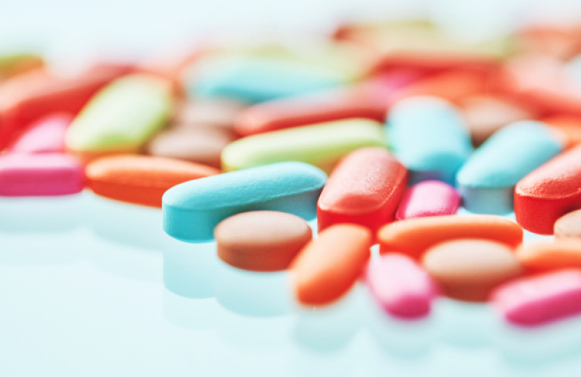 Colorful pills on a reflective surface