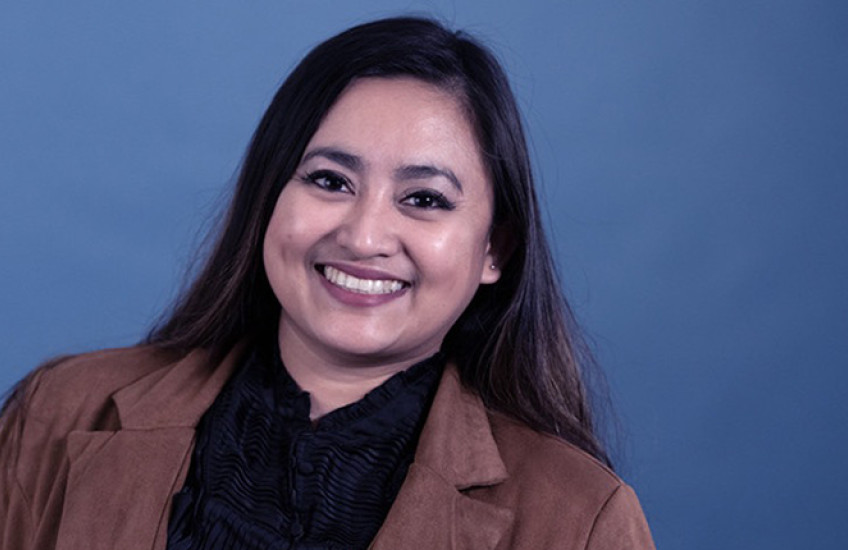 portrait photo of a smiling Filipino-American woman wearing a blazer