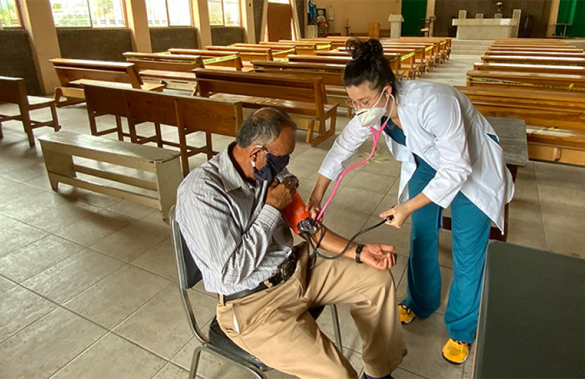 Sedas taking a patient's blood pressure reading at a community church
