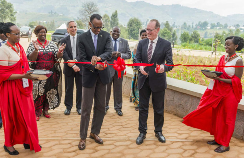 Two men cut a bright red celebratory ribbon.