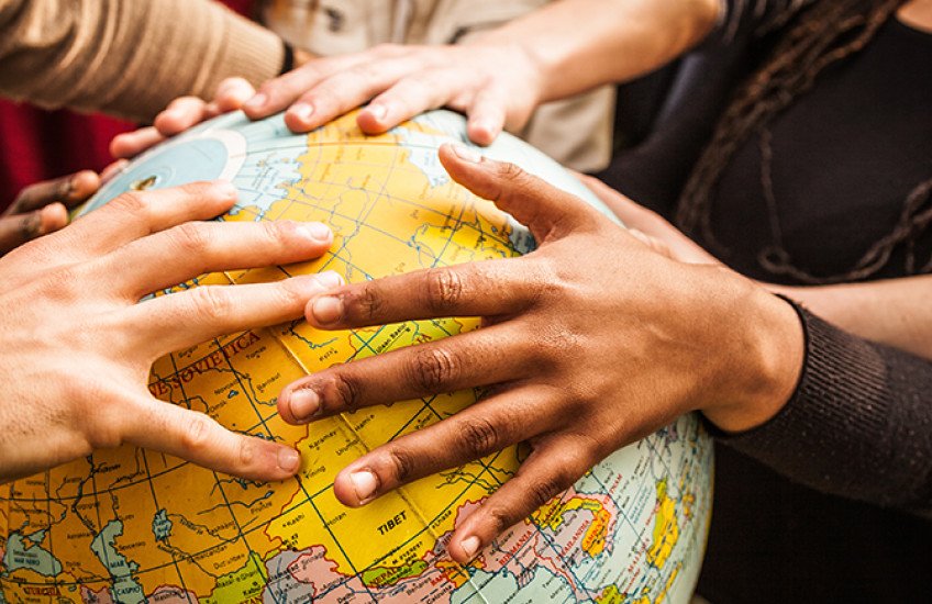 multiethnic hands on a globe