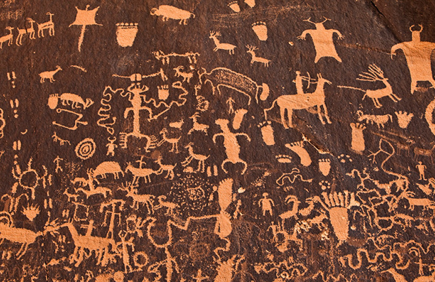 ancient cave art showing people and animals