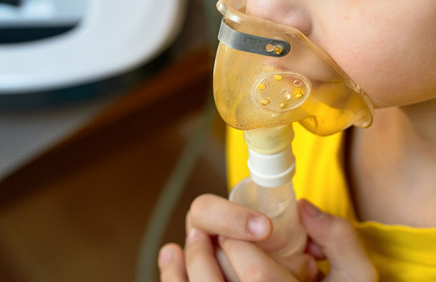 close up of child's face making an inhalation with a nebulizer