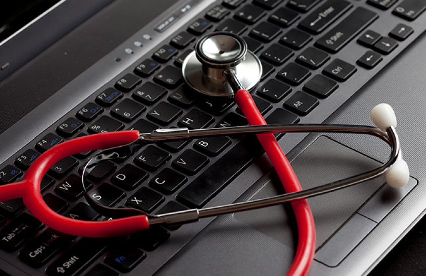 red stethoscope on laptop computer 