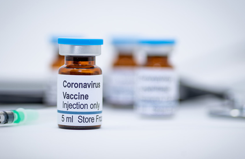 photo of vials with COVID-19 vaccine label and needle