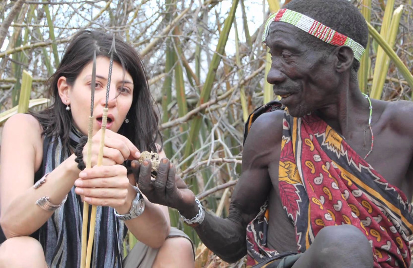 Two people look at a bow and arrow