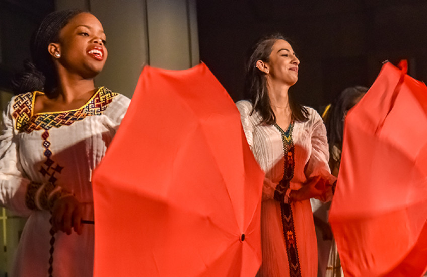 fabric performers in African dress twirling umbrellas