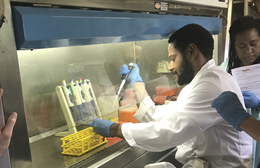 Man with pipette while others look on