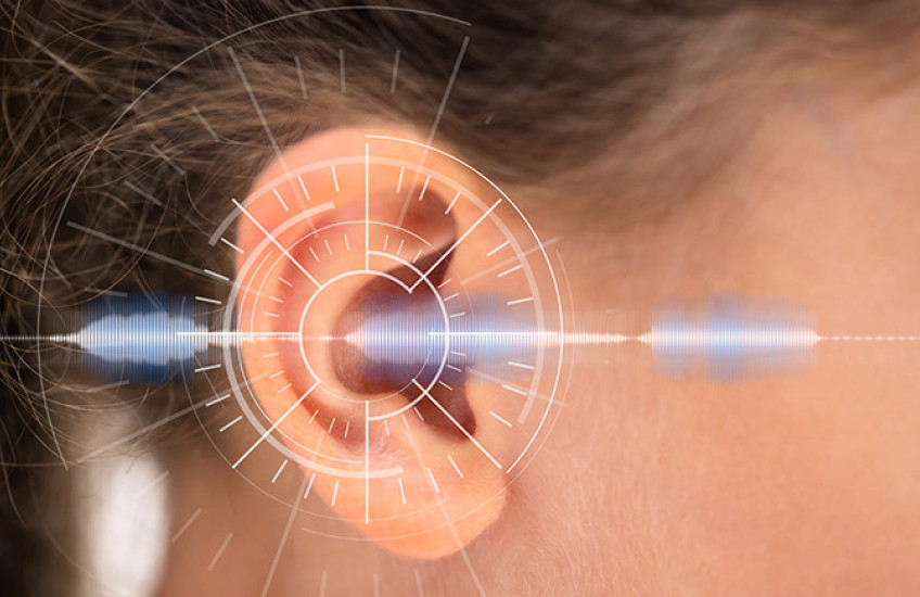 Close up of a white child's ear with a sound wave overlaid digitally